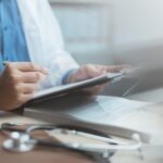 Doctor,Writing,Medical,Notes,On,A,Clipboard,With,A,Stethoscope