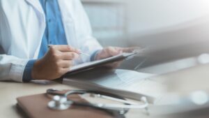 Doctor,Writing,Medical,Notes,On,A,Clipboard,With,A,Stethoscope