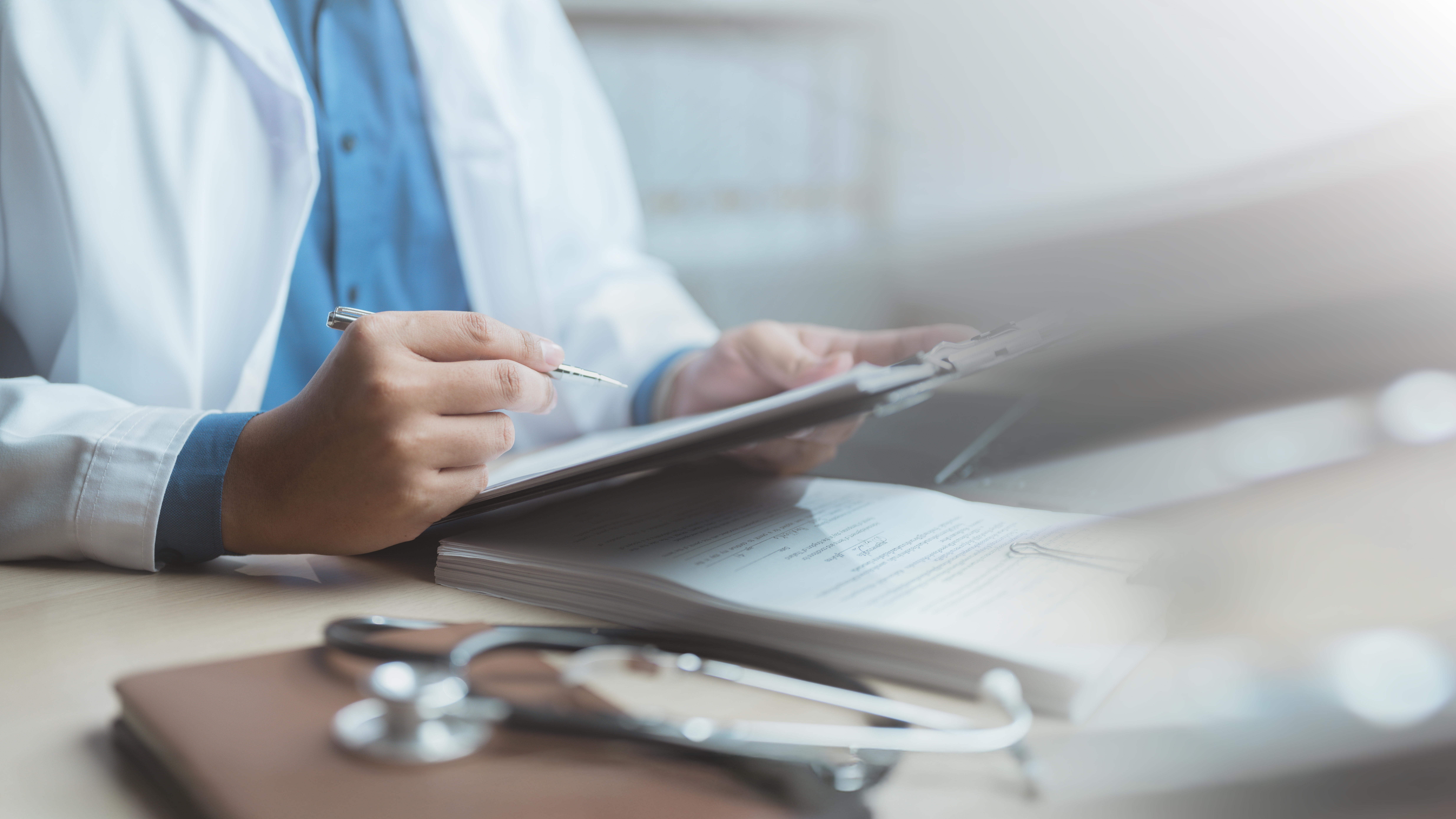 Doctor,Writing,Medical,Notes,On,A,Clipboard,With,A,Stethoscope